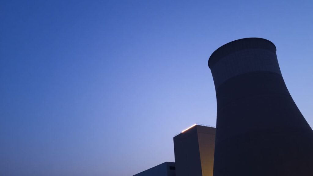 Nuclear power plant with cooling towers against a sky.
